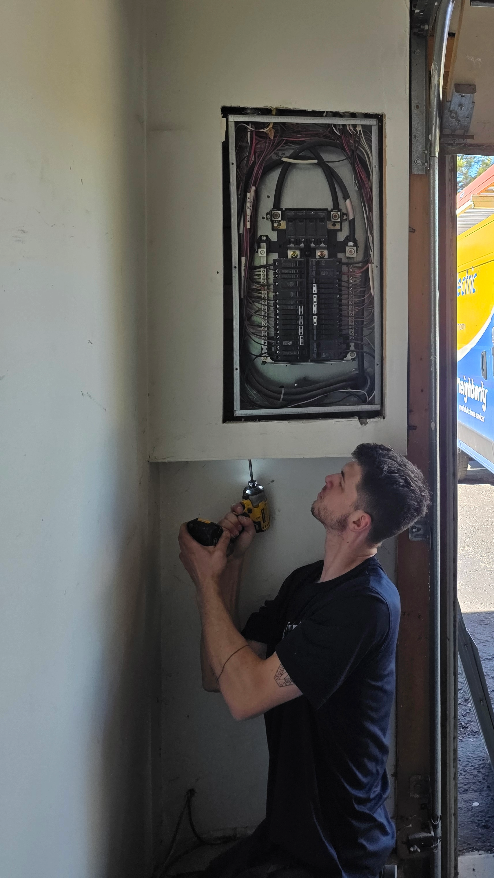 Professional electrician working inside an electrical panel